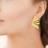 Boucles d'oreille Claudia, motif XL effet drapé et texturé en acier pvd doré. Présentées portées.