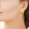 Boucles d'oreille puces, bouton texturé effet tweed. En acier pvd doré. Présentées portées.