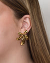 Boucles d'oreille Loanne motif fleur XL, en acier pvd doré. Présentées portées.